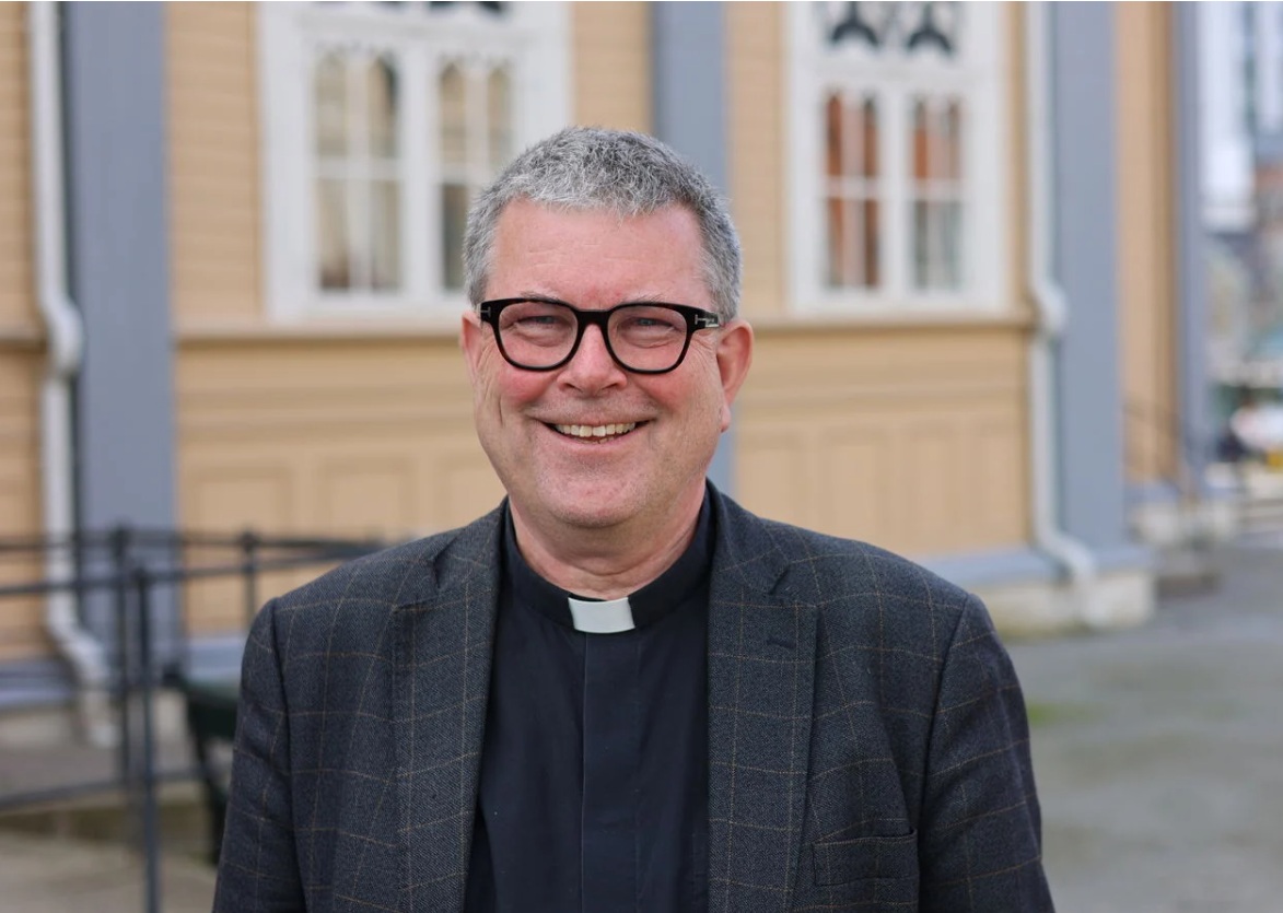 Portrettbilde av Stig Lægdene med domkirka i Tromsø i bakgrunnen